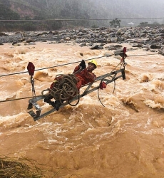 Xúc động hình ảnh người công nhân điện treo mình trên dòng nước lũ